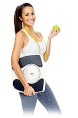 Mujer deportista sujetando un báscula, una manzana y una cinta métrica