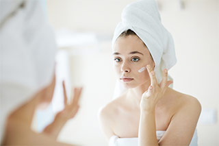 mujer aplicando crema para hiperpigmentacion