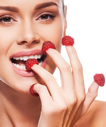Mujer comiendo frambuesas con los dedos